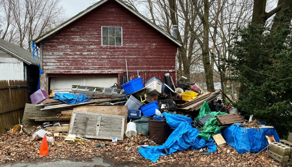 Junk removal Colorado Springs – cluttered home exterior with junk and old furniture piled in front, showing the need for professional cleanup to improve curb appeal