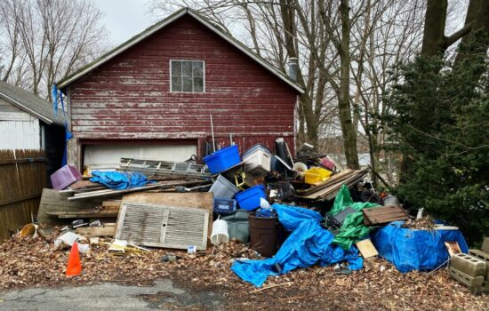 Junk removal Colorado Springs – cluttered home exterior with junk and old furniture piled in front, showing the need for professional cleanup to improve curb appeal